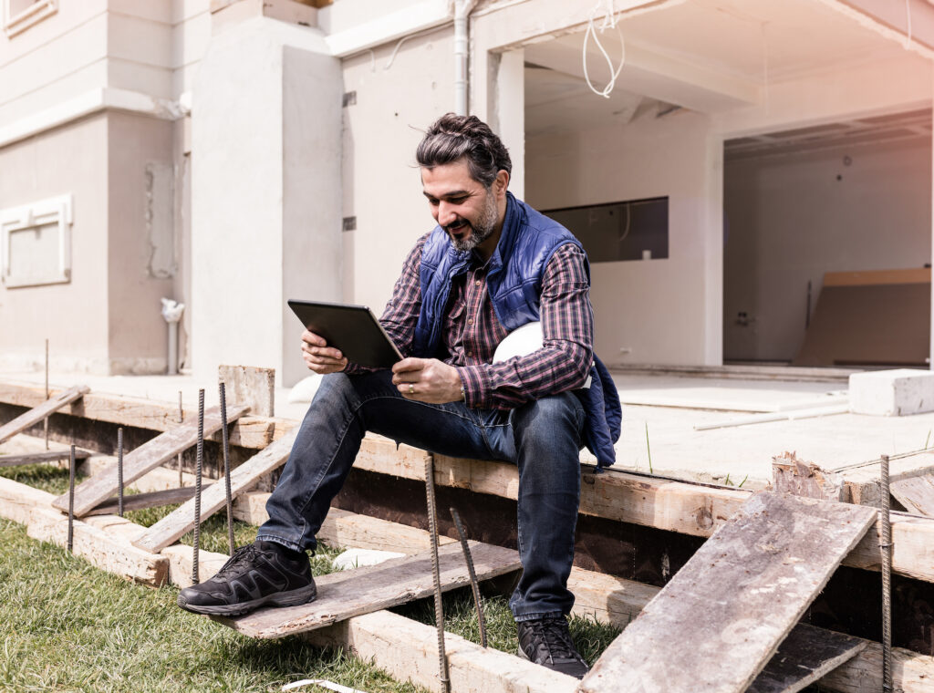 Man sitting on a porch using a mobile tablet
