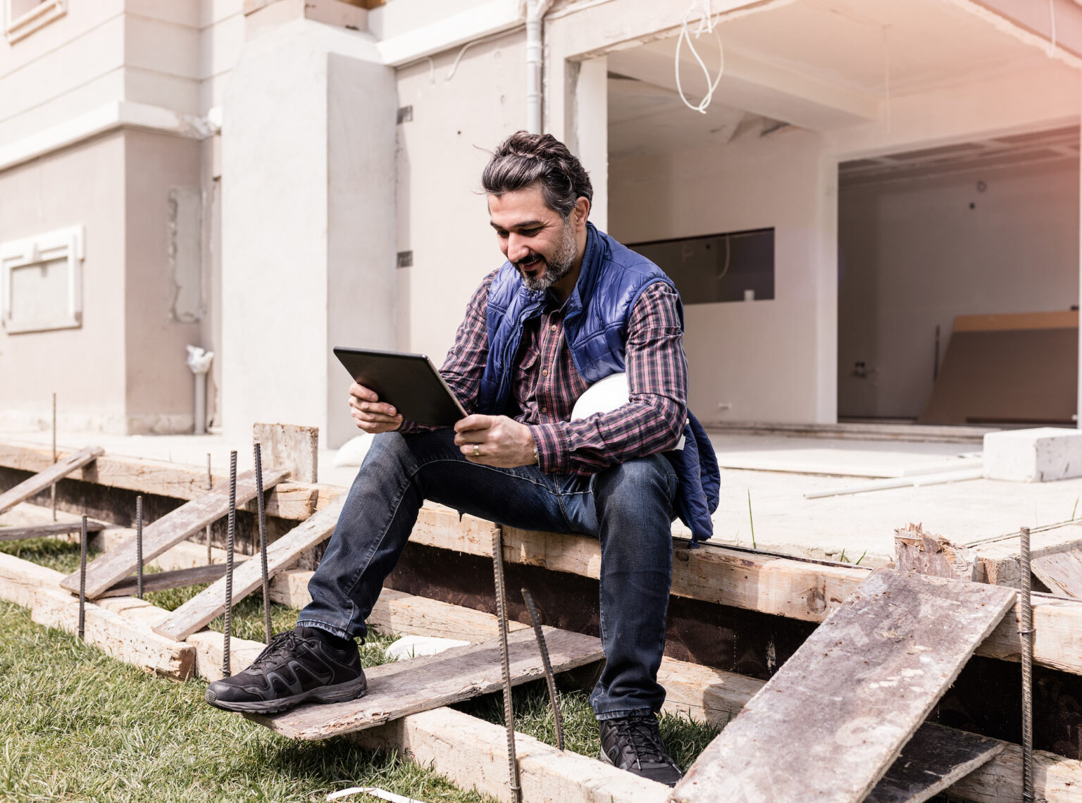 Man sitting on a porch using a mobile tablet