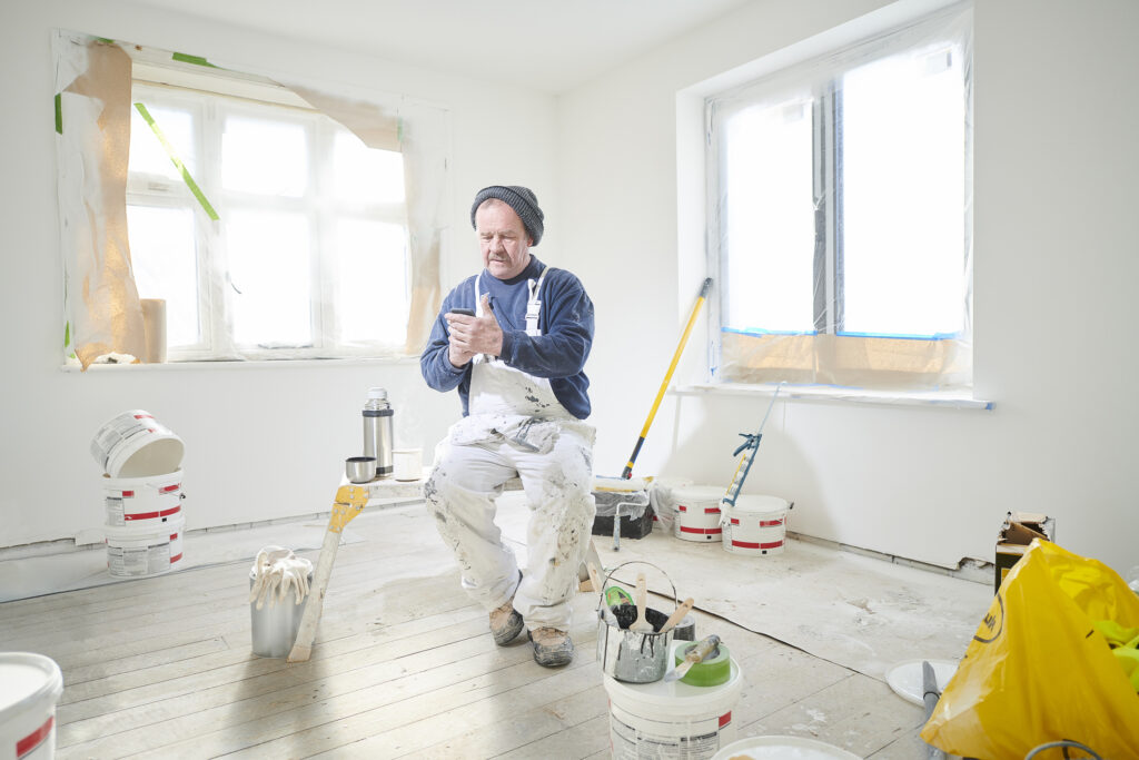 painter sitting in room on phone using social media