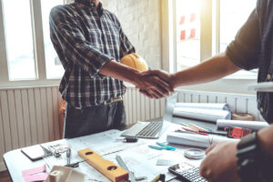 two blue collar workers shaking hands
